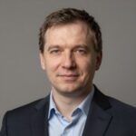 Портрет уверенного российского бизнесмена с дружелюбным взглядом на размытом нейтральном фоне в студии